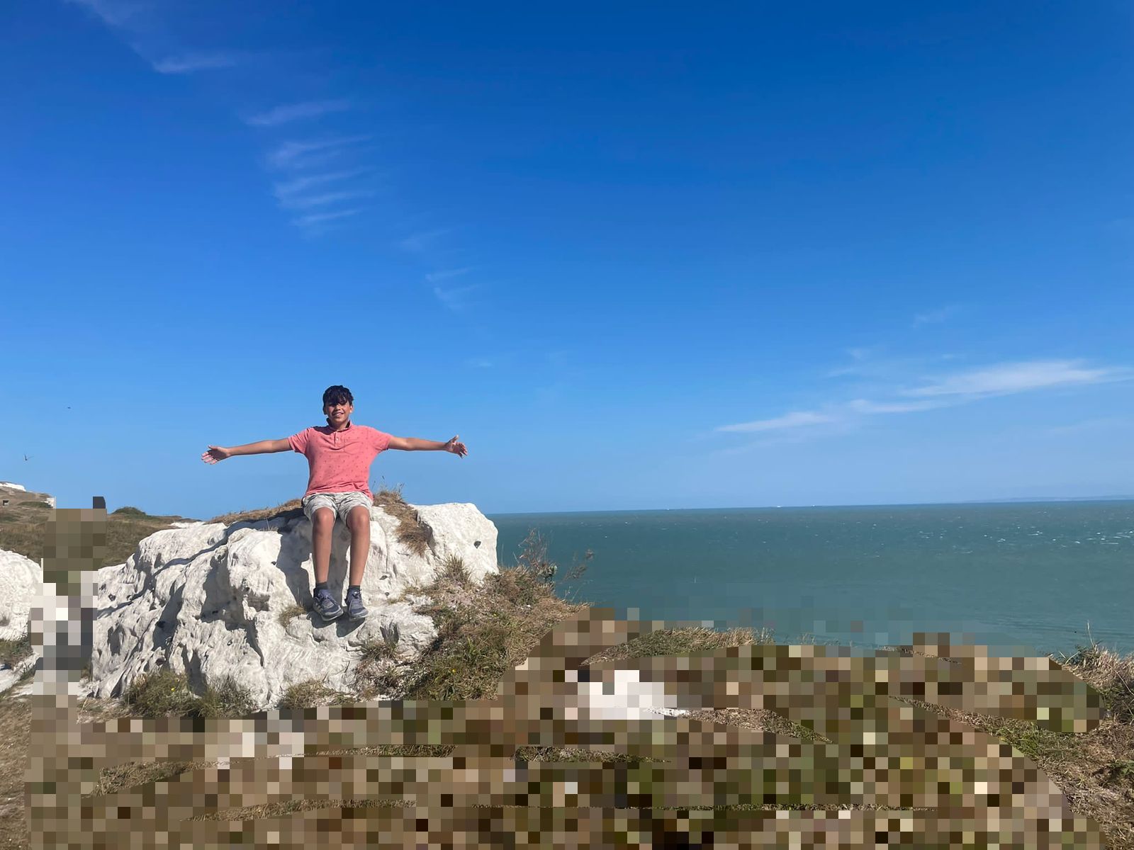A boy standing on a rock with arms open - freedom and hope